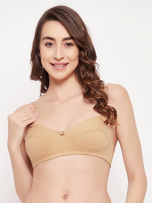 Woman's arm holding a beige bra Stock Photo